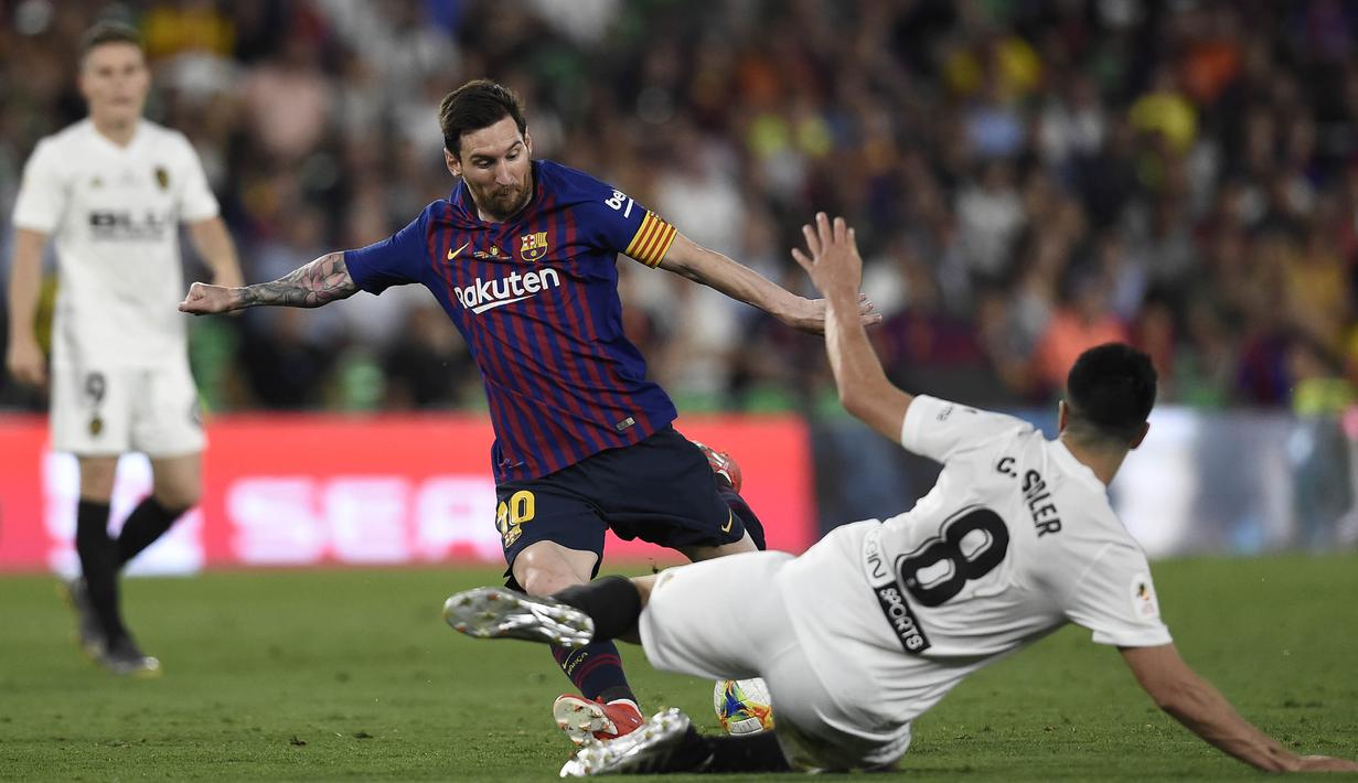 Gelandang Barcelona, Lionel Messi, berusaha melewati gelandang Valencia, Carlos Soler, pada laga Copa del Rey di Stadion Benito Villamarin, Sevilla, Sabtu (25/5). Barcelona kalah 1-2 dari Valencia. (AFP/Pau Barrena)