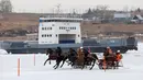 Peserta memacu troika selama bersaing dalam balapan kuda Ice Derby di Sungai Yenisei yang membeku, Krasnoyarsk, Rusia, Sabtu (16/3). Kejuaraan balap kuda ini arenanya berada di atas sungai yang membeku. (Reuters/Ilya Naymushin)