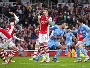 Pemain Arsenal (kiri) bereaksi setelah pemain Manchester City Rodrigo mencetak gol pada pertandingan sepak bola Liga Inggris di Stadion Emirates, London, Inggris, 1 Januari 2022. Manchester City menang 2-1. (AP Photo/Matt Dunham)