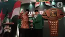 Menko Polhukam Mahfud Md menerima cindera mata dari Plt Ketua Umum PPP Suharso Monoarfa saat membuka Musyawarah Kerja Nasional (Mukernas) ke V PPP di Jakarta, Sabtu (14/12/2019). Salah satu agenda yang akan dibahas dalam acara ini adalah pelaksanaan Muktamar PPP. (Liputan6.com/Angga Yuniar)