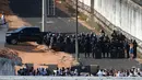 Seorang tahanan berbicara dengan polisi setelah bentrokan di penjara Alcacuz, Natal, Rio Grande do Norte, Brasil, (16/1). Polisi harus menggunakan peluru karet untuk membubarkan bentrokan antar geng tersebut. (AFP Photo/Andressa Anholette)
