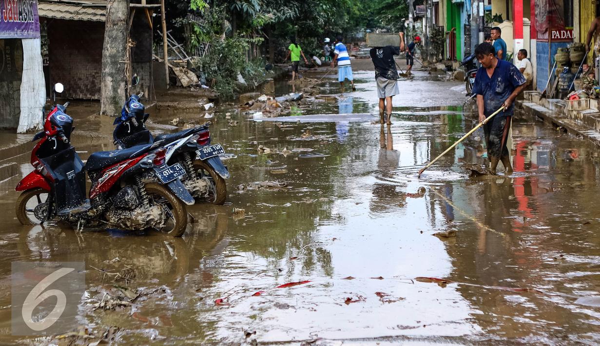 Warga membersihkan jalan yang dipenuhi lumpur usai banjir menggenangi komplek Pondok Gede Permai Jatiasih, Bekasi, Jumat (22/04). (Liputan6.com/Fery Pradolo)