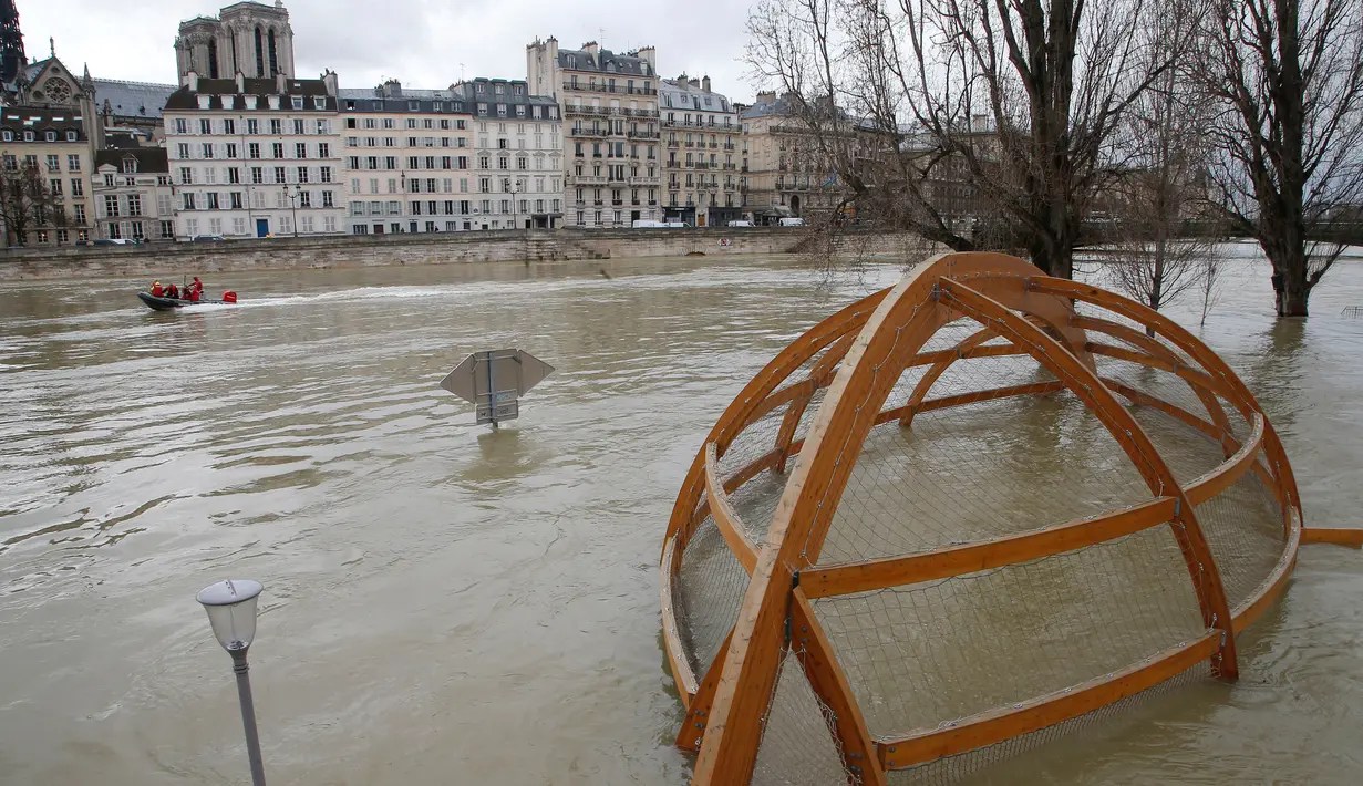 Luapan air Sungai Seine merendam taman bermain di Paris, Senin (29/1). Tingkat air diprediksi akan tetap tinggi sepanjang minggu, karena curah hujan yang masih tinggi dan diperkirakan masih akan memperburuk keadaan banjir ini. (AP Photo/Michel Euler)