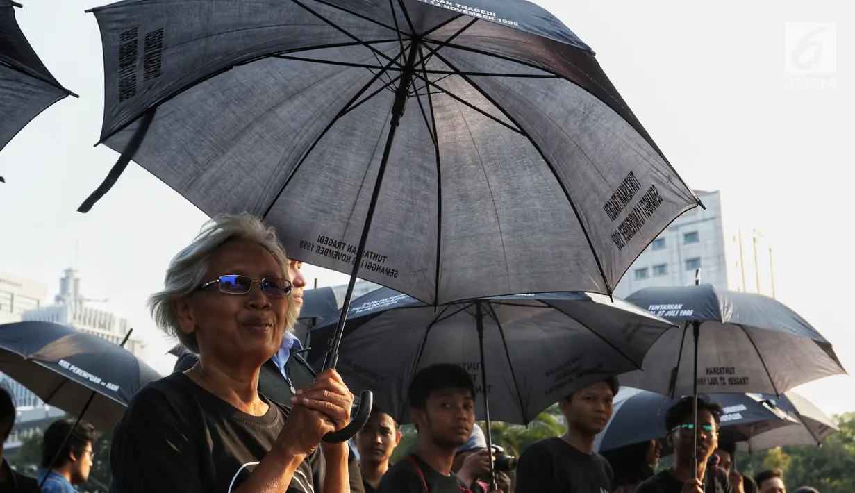 Aktivis Jaringan Solidaritas Korban untuk Keadilan (JSKK) menggelar aksi Kamisan ke-589 di depan Istana Merdeka, Jakarta, Kamis (20/6/2019). Dalam aksinya, JSKK meminta Presiden Joko Widodo memegang teguh komitmen untuk menyelesaikan pelanggaran HAM berat masa lalu. (Liputan6.com/Johan Tallo)
