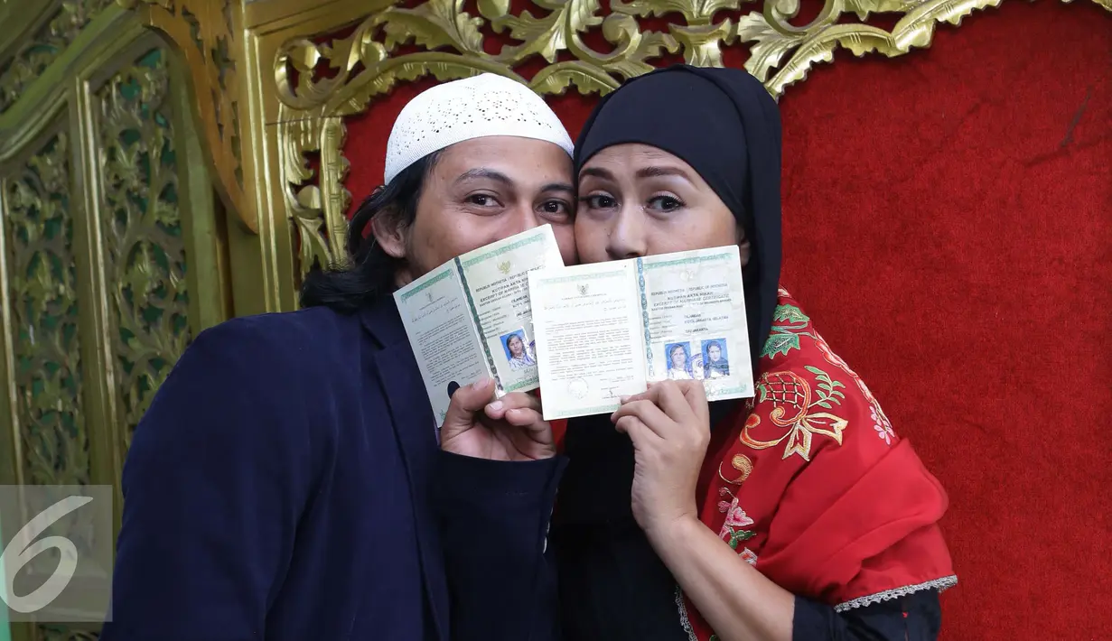 Ria Irawan bersama suaminya, Mayky Wongkar berpose menunjukan buku nikah usai Ijab Qabul di KUA Cilandak, Jakarta, Jumat (23/12). Akhirnya setelah 17 tahun menjanda, Ria menikah untuk kedua kalinya dengan asistennya sendiri. (Liputan6.com/Herman Zakharia)