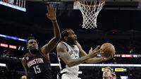 Pemain San Antonio Spurs, Kawhi Leonard (kanan) melakuka layup melewati adangan pemain Houston Rockets, Clint Capela  pada gim kelima NBA basketball playoff series di San Antonio, (9/5/2017). Spurs menang 110-107. (AP/Eric Gay)