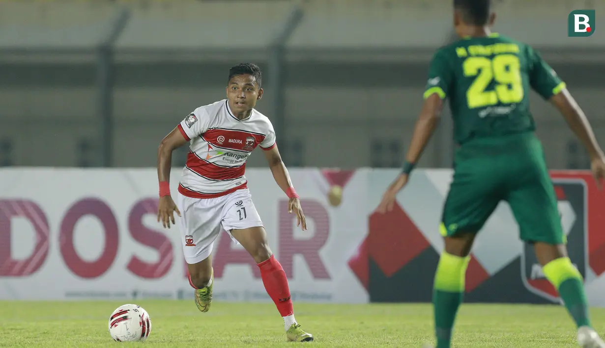 Bek Madura United, Fadilah Nur Rahman (kiri) berusaha melewati bek Persebaya Surabaya, Mokhamad Syaifuddin dalam laga matchday ke-2 Grup C Piala Menpora 2021 di Stadion Si Jalak Harupat, Bandung, Minggu (28/3/2021). Madura United kalah 1-2 dari Persebaya. (Bola.com/M Iqbal Ichsan)