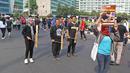 Jurnalis yang tergabung dalam Aliansi Jurnalis Independen (AJI) memainkan kentongan saat menggelar aksi menuntut pencabutan status tersangka Dandhy Dwi Laksono pada Car Free Day di Kawasan Bundaran HI, Jakarta, Minggu (29/9/2019). (Liputan6.com/Herman Zakharia)