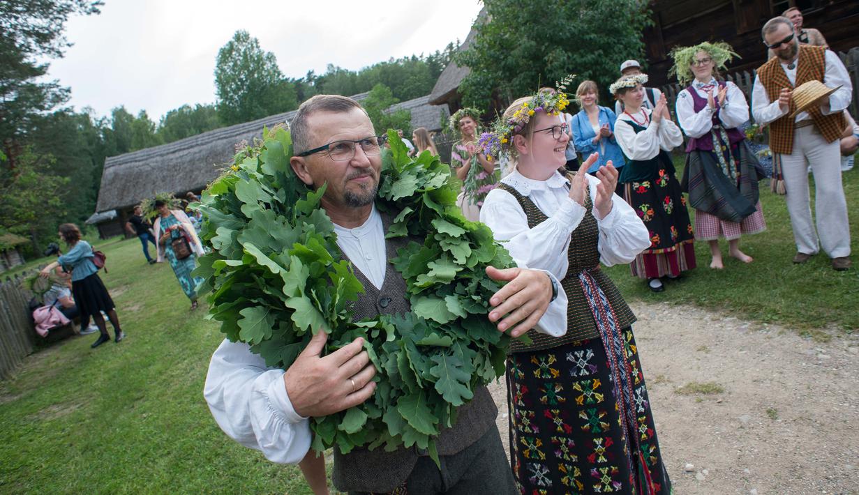 Sejumlah warga mengikuti Festival Rasos di Rumsiskes, Lithuania, Selasa (23/6/2020). Orang-orang merayakan festival ini dengan mengenakan sejumlah hiasan bunga dan kostum tradisional serta bernyanyi dan menari. (Xinhua/Alfredas Pliadis)