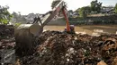 Alat berat melakukan pengerukan tumpukan sisa lumpur dan tanah yang menumpuk di pinggir kali Ciliwung, Jakarta, Kamis (28/7). Tumpukan tanah dan lumpur sisa dari pengerukan kali Ciliwung mulai dibersihkan.(Liputan6.com/Yoppy Renato)