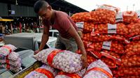 Pekerja menurunkan karung berisi bawang putih di Pasar Induk Kramatjati, Jakarta Timur, Rabu (5/2/2020). Kelangkaan pasokan bawang putih di dalam negeri berimbas tingginya harga komoditas tersebut yang mencapai kisaran Rp 57.500/kilogram. (merdeka.com/magang/ Muhammad Fayyadh)