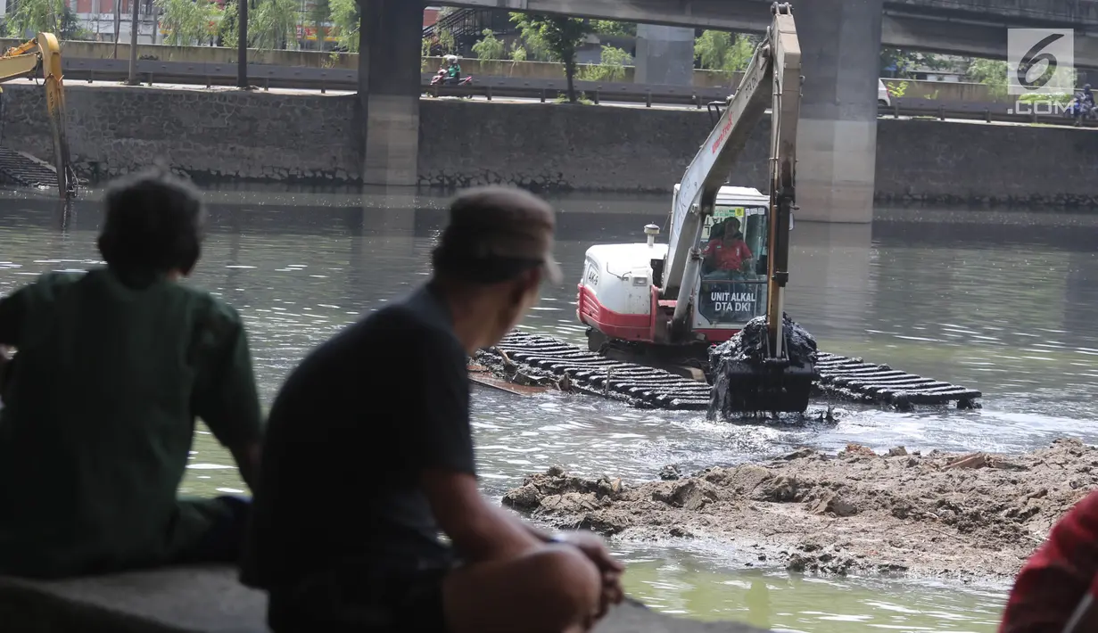 Warga menyaksikan proses pengerukan Waduk Grogol, Jakarta, Senin (9/4). Pengerukan dilakukan untuk mengatasi permasalahan banjir di Ibu Kota. (Liputan6.com/Arya Manggala)