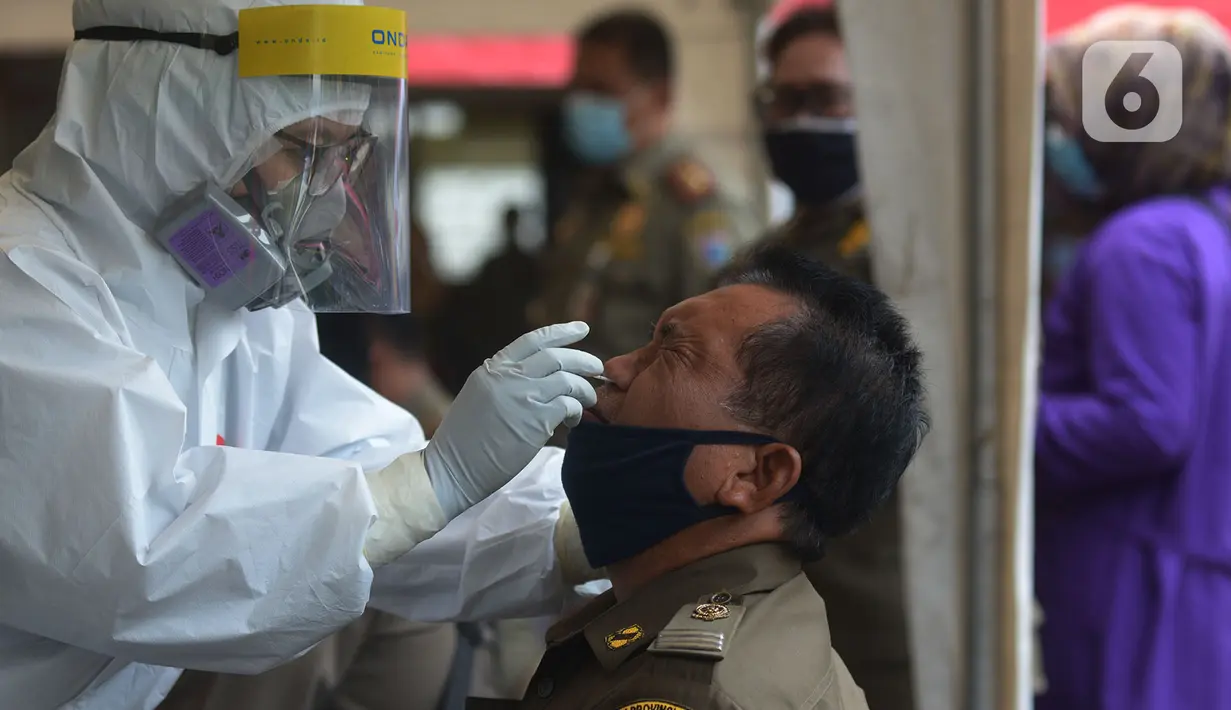 Petugas medis mengambil sampel lendir saat tes usap (swab test) pegawai kecamatan Sawah Besar, Jakarta, Selasa (18/8/2020). Tes swab yang dilakukan terhadap seluruh pegawai kecamatan Sawah Besar itu sebagai upaya memutus mata rantai penyebaran Virus Corona Covid-19. (merdeka.com/Imam Buhori)