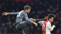 Gelandang Bayern Munchen Thomas Mueller (kiri) menendang kepala bek Ajax Amsterdam Nicolas Tagliafico dalam laga Grup E Liga Champions di Amsterdam, Belanda, Rabu (12/12). Mueller disebut tak sengaja saat insiden itu terjadi. (EMMANUEL DUNAND/AFP)