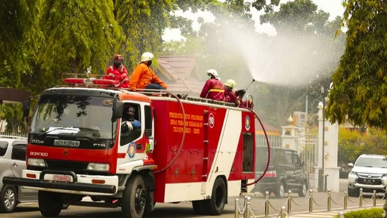 Petugas Pemadam Kebakaran Kota Pekanbaru menyemprotkan cairan disinfektan untuk mencegah penyebaran virus corona.