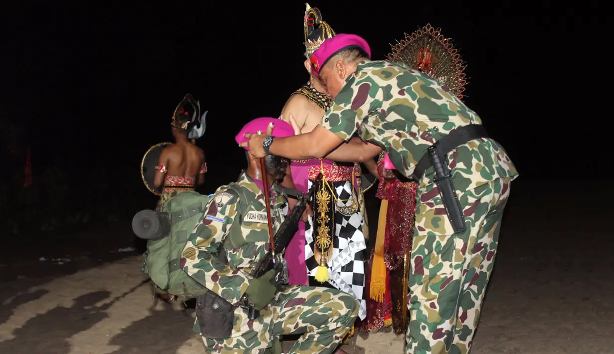 Komandan Korps Marinir (Dankormar) Mayjen TNI (Mar) Bambang Suswantono memakaikan baret kepada perwakilan Tamtama Remaja Marinir saat upacara Pembaretan di Pantai Nganteb, Malang Selatan, Jawa Timur, Kamis (12/4). (Liputan6.com/Pool/Marinir TNI-AL)