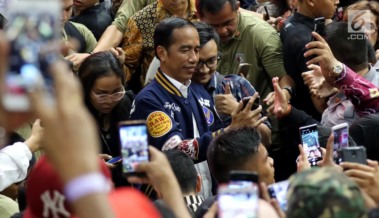 Calon Presiden petahana Joko Widodo swafoto bersama kaum milenial ketika menghadiri Festival Satu Indonesia di Istora, Senayan, Jakarta, Minggu (10/3). Acara yang dihadiri kaum millenial mengajak pemilih untuk tidak golput. (Liputan6.com/Johan Tallo)