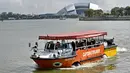 Sebuah wahana amfibi yang membawa turis melewati Stadion Nasional di Singapura pada 19 Februari 2019. Mobil-perahu mirip bebek ini mengantarkan pelancong berpetualang seru melihat keindahan Negeri Singa melalui jalur darat dan sungai. (Roslan RAHMAN/AFP)