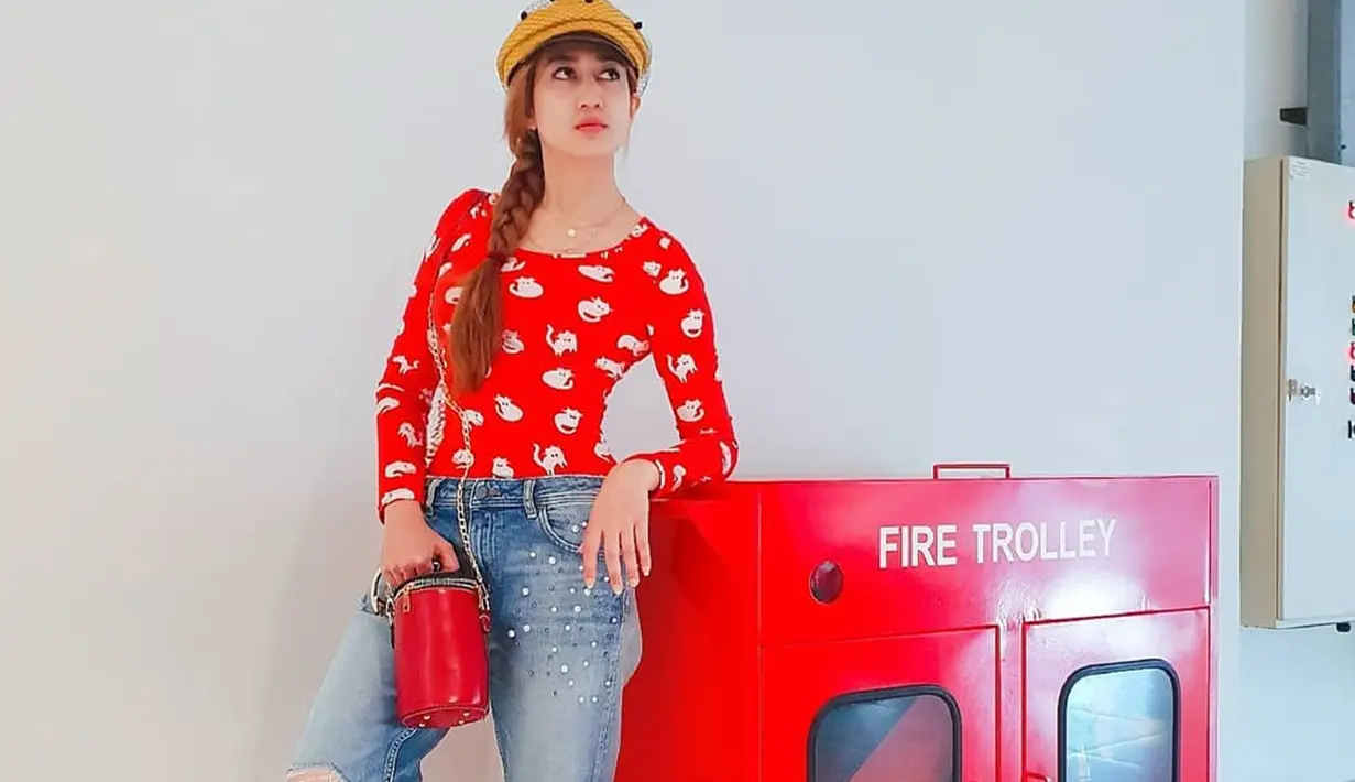 Dengan gaya santai kaos panjang berwarna merah dipadukan celana jeans serta topi hits kekinian menambah pesona Helamia yang makin menawan ya! (Liputan6.com/IG/@akuhelmalia)