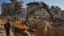 Warga Palestina menyaksikan alat berat dan beberapa pekerja dari Mesir mencari jenazah sandera di Kota Hamad, Khan Younis, bagian selatan Jalur Gaza, pada Minggu 26 Oktober 2025. (AP Photo/Jehad Alshrafi)