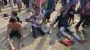 Sejumlah warga kelelahan usai mengikuti lomba Panjat Pinang Kolosal dalam rangka merayakan HUT RI ke-70 di Pantai Karnaval, Ancol, Jakarta, Senin (17/8). Sebanyak 124 batang pinang disediakan dengan berbagai ragam hadiah. (Liputan6.com/Herman Zakharia)