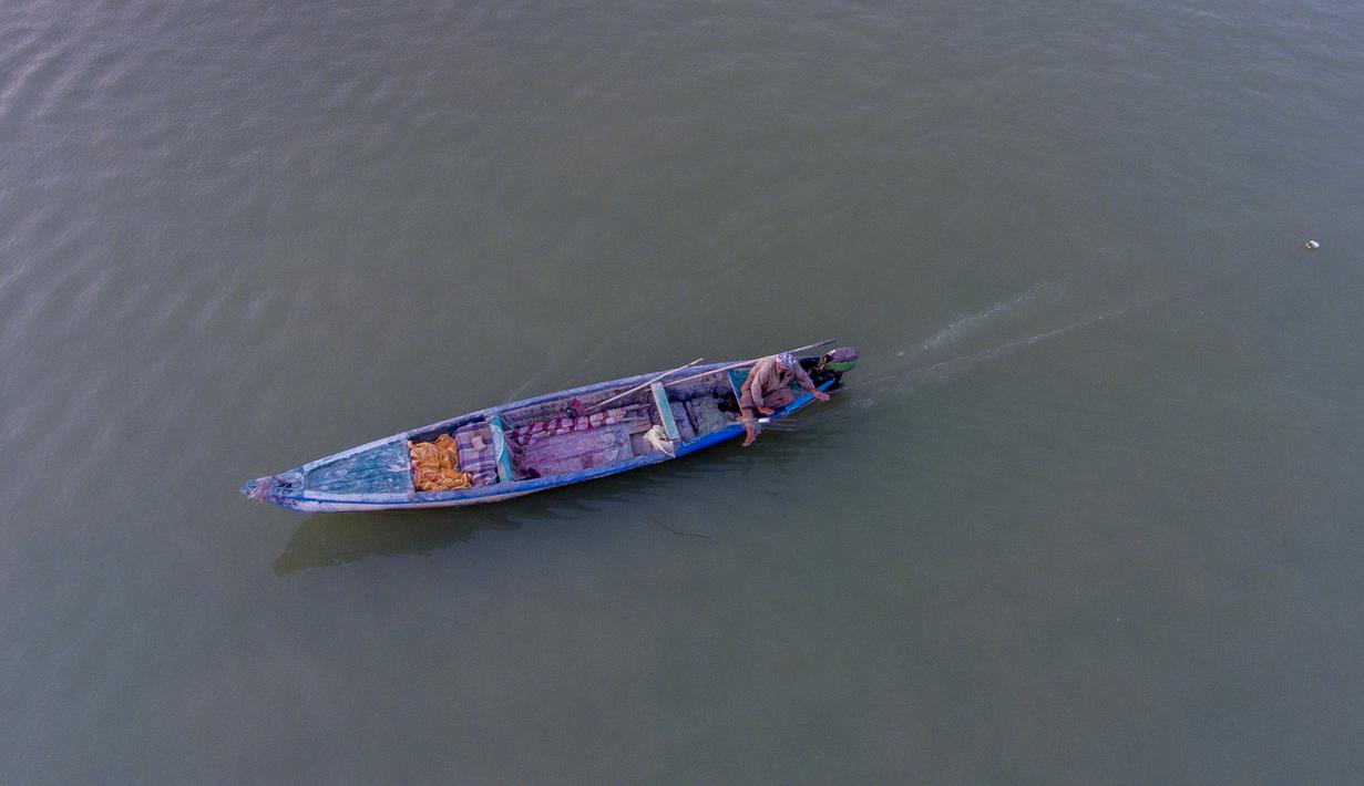 Foto udara ini menunjukkan seorang nelayan di perahunya di jalur air Shatt al-Arab, di Basra, Irak, Selasa (7/6/2022). Ujung selatan sungai ini menandai perbatasan antara Irak dan Iran. Lebar sungai Shatt al-Arab bervariasi antara sekitar 232 meter di Basra hingga 800 meter di mulut sungai. (AP Photo/Nabil al-Jurani)
