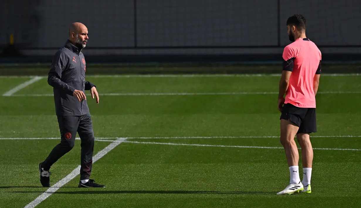 Pelatih Manchester City, Pep Guardiola (kiri) berbicara kepada pemainnya, Josko Gvardiol saat memimpin sesi latihan timnya di Manchester City Training Ground, Manchester (18/9/2023) waktu setempat, jelang menghadapi Red Star Belgrade pada matchday pertama Grup G Liga Champions 2023/2024 di Etihad Stadium, Rabu (20/9/2023) dini hari WIB. (AFP/Paul Ellis)