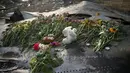 Untaian bunga dan mainan anak diletakkan di salah satu sisa badan pesawat Malaysia Airlines MH-17 yang jatuh dan terbakar di Donetsk, Ukraina, (19/7/2014). (REUTERS/Maxim Zmeyev)