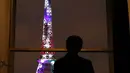 Putra Mahkota Jepang, Naruhito melihat ke arah Menara Eiffel yang berhias cahaya warna-warni di Paris, Perancis, Kamis (13/9). Pertunjukan ini dipersembahkan oleh seniman Jepang, Motoko Ishii. (AP Photo/Christophe Ena)