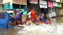 Sejumlah anak-anak asyik bermain di atas sebuah mobil yang terendam banjir di kawasan Grogol, Jakarta Barat, Rabu (11/2/2015). (Liputan6.com/Faisal R Syam)