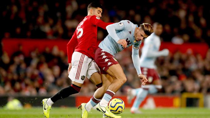 Pemain Manchester United Andreas Pereira (kiri) berebut bola dengan pemain Aston Villa Jack Grealish saat bertanding pada pertandingan Liga Inggris di Old Trafford, Manchester, Inggris, Minggu (1/12/2019). Skor berakhir 2-2. (Martin Rickett/PA via AP)