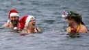 Puluhan anggota klub renang es "Berliner Seehunde" merayakan Natal dengan berenang di danau Orankesee, Berlin (25/12/2014). Tampak, beberapa anggota klub berenang di danau Orankesee, Berlin. (REUTERS/Fabrizio Bensch)