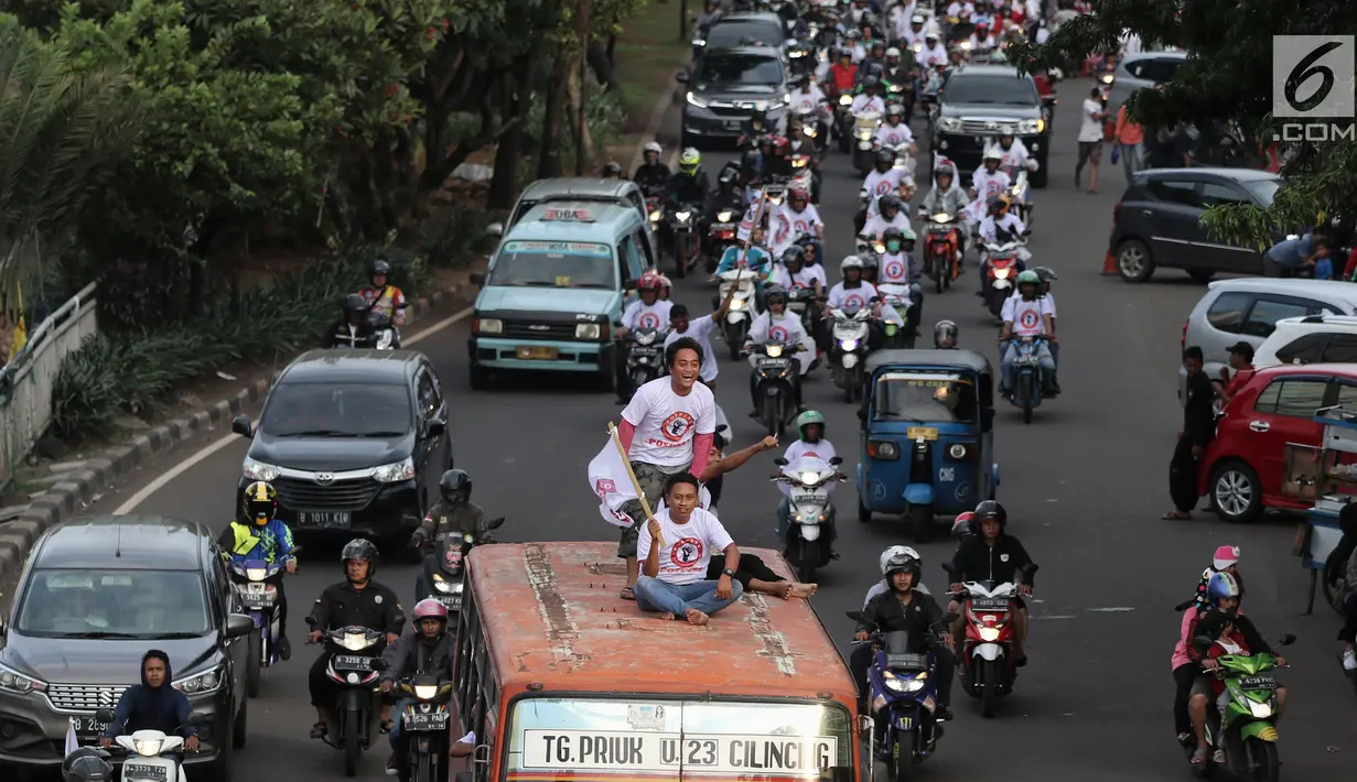 Relawan capres dan cawapres nomor urut 01 Joko Widodo atau Jokowi dan Ma'ruf Amin menggelar konvoi menuju lokasi debat Pilpres 2019 di Jakarta, Minggu (17/2). Massa memberi dukungan untuk Jokowi yang akan mengikuti debat. (Liputan6.com/JohanTallo)
