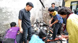 Ketua Komnas PA Seto Mulyadi (batik biru) bersama petugas Komnas PA lainnya mencari berkas yang bisa diselamatkan pasca-kebakaran di kantor tersebut pada 28 Juni lalu, di kawasan Pasar Rebo, Jakarta, Senin (29/6/2015). (Liputan6.com/Yoppy Renato)