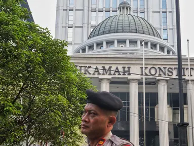 Polisi berjaga menjelang sidang perdana MK Pemilu 2019 di halaman depan Gedung Mahkamah Konstitusi, Jakarta, Jumat, (14/6/2019). Sekitar 30 ribu pesonil gabungan diterjunkan untuk mengawal jalannya sidang. (Liputan6.com/Johan Tallo)