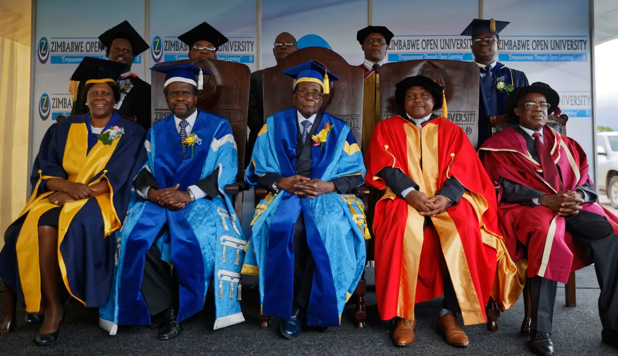 Presiden Zimbabwe, Robert Mugabe berfoto bersama pejabat Universitas Terbuka Zimbabwe usai memimpin upacara wisuda di Harare, Jumat (17/11). Mugabe untuk pertama kalinya muncul di hadapan publik setelah menjadi tahanan rumah. (AP Photo/Ben Curtis)