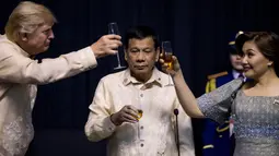 Presiden AS, Donald Trump bersulang dengan Ibu Negara Filipina, Cielito "Honeylet" Avancena disaksikan Presiden Filipina, Rodrigo Duterte dalam acara makan malam bersama konferensi ASEAN ke-31 di Manila, Minggu (12/11). (Athit Perawongmetha/Pool via AP)