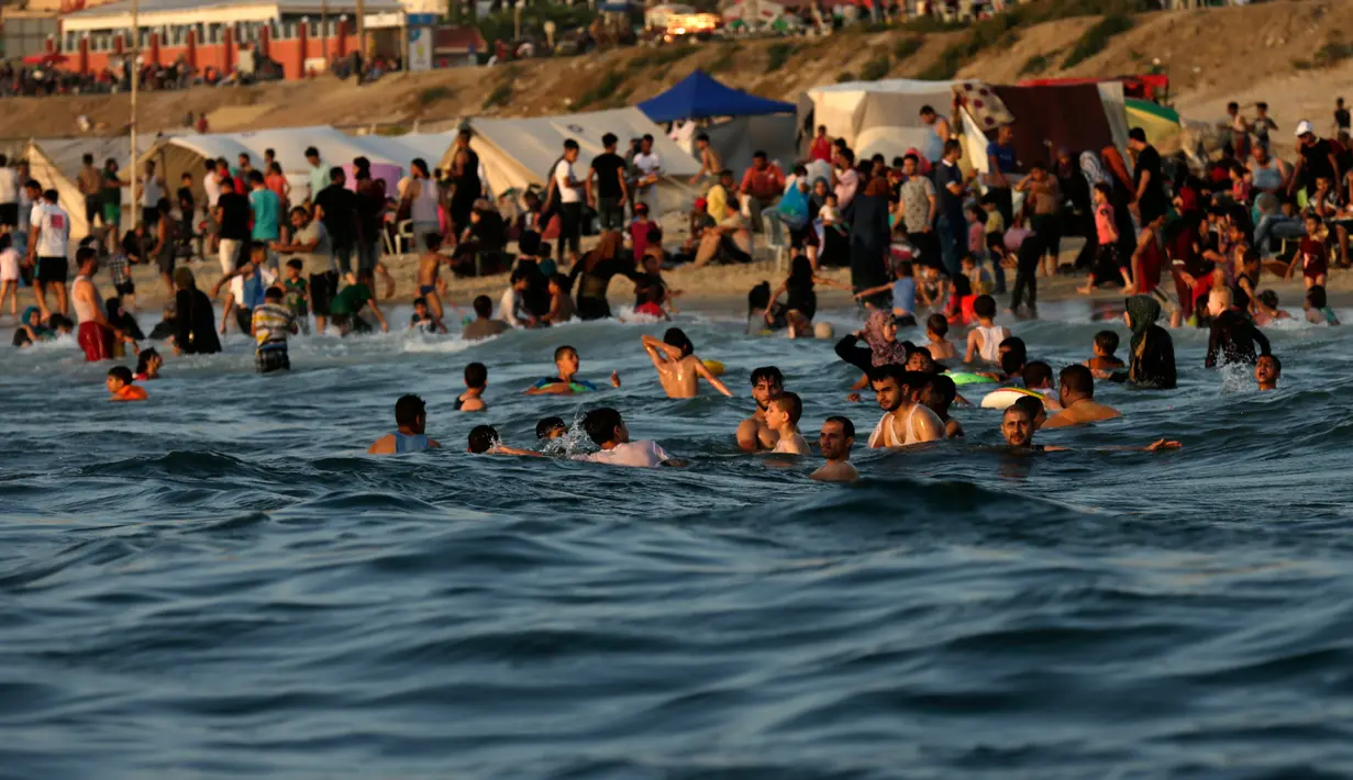 Sejumlah warga Palestina bermain dan berenang di pantai Kota Gaza, Jumat (22/6). Panasnya konflik antara Palestina dan Israel membuat penduduk di kawasan Gaza hanya bisa mengandalkan Pantai Gaza sebagai tempat wisata. (AFP PHOTO/MAHMUD HAMS)