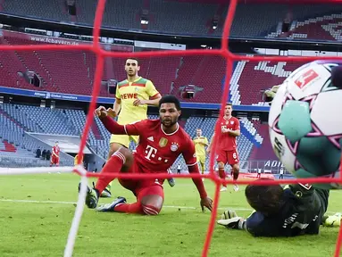 Striker Bayern Munchen, Serge Gnabry, mencetak gol ke gawang FC Koln pada laga Bundesliga di Stadion Allianz, Minggu (27/2/2021). Bayern menang dengan skor 5-1. (Sven Hoppe/dpa via AP)