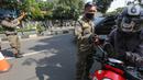 Petugas memeriksa identitas pengendara bermotor pada hari pertama PSBB di jalur check point Jalan Ir. H Juanda, Ciputat, Tangerang Selatan, Sabtu (18/4/2020). PSBB resmi diberlakukan di Kabupaten Tangerang, Kota Tangerang dan Tangerang Selatan hingga 1 Mei 2020. (Liputan6.com/Fery Pradolo)