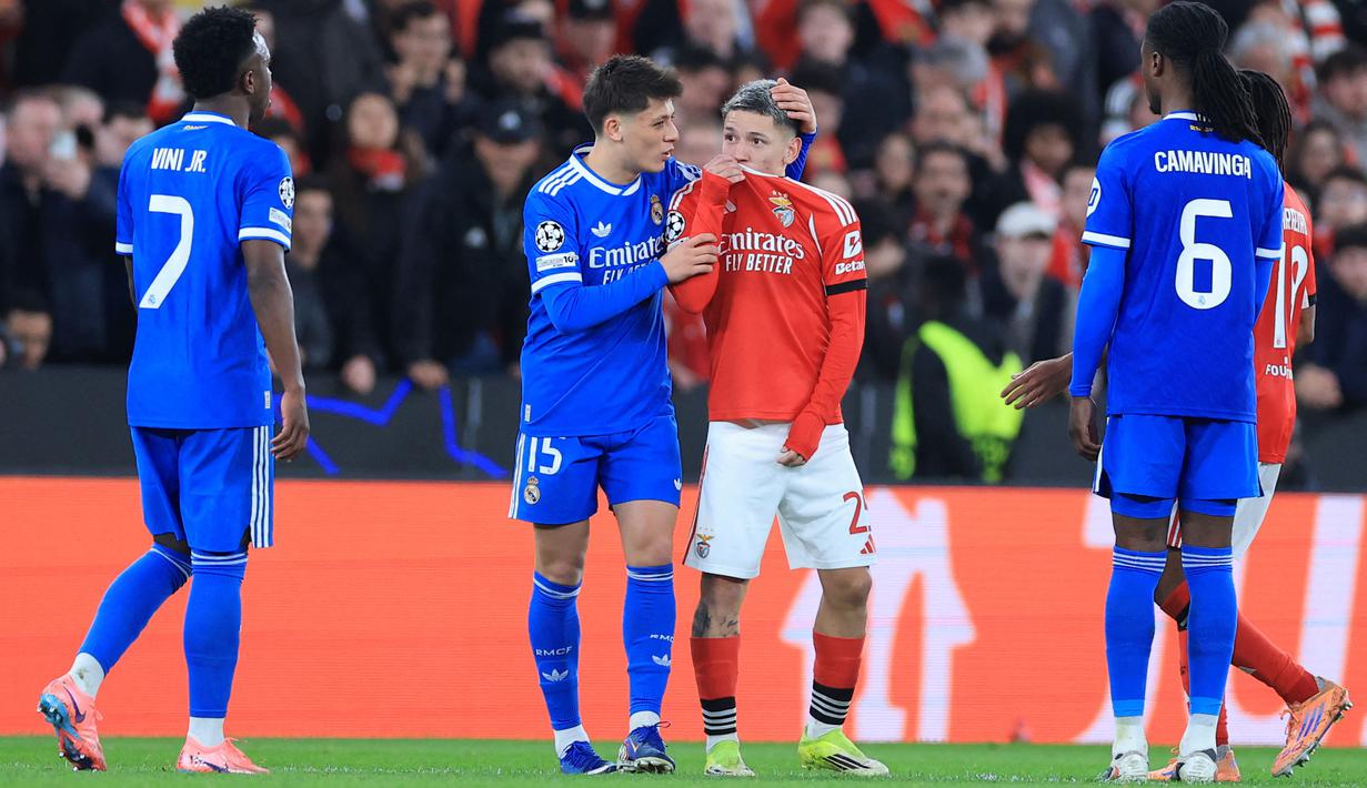 Kylian Mbappe menilai winger Benfica, Gianluca Prestianni, tidak pantas lagi tampil di kompetisi elite Eropa tersebut setelah dugaan tindakan pelecehan rasial terhadap Vinicius. Meskipun begitu Prestianni tidak mendapat kartu kuning atau merah dari wasit. Ia terlihat menutup mulutnya dengan jersey, sehingga wasit tidak menemukan bukti verba. (AFP/Patricia De Melo Moreira)