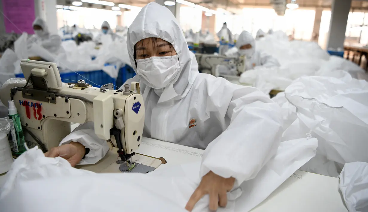 Pekerja menjahit bahan untuk digunakan membuat pakaian antivirus di pabrik garmen Zhejiang Ugly Duck Industry, di Wenzhou, 28 Februari 2020. Wabah virus corona di China membuat produsen pakaian itu mulai memproduksi baju hazmat yang banyak diburu orang untuk melindungi dirinya. (NOEL CELIS/AFP)