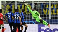 Kiper Inter Milan, Andre Onana berusaha menghalau bola tendangan pemain Benfica pada laga leg kedua perempat final Liga Champions 2022/2023 di Giuseppe-Meazza, Milan, 19 April 2023. (AFP/Gabriel Bouys)