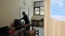 Seorang guru pengawas merapikan tas para siswa peserta UNKP di ruang khusus SLB Negeri 7 Jakarta, Selasa (24/4). Seluruh siswa yang mengikuti ujian tersebut merupakan penyandang tunarungu. (Merdeka.com/Iqbal Nugroho)