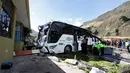 Polisi dan petugas penyelamat bekerja memindahkan bus pembawa turis asal Kolombia dan Venezuela di Pifo, Ekuador, Selasa (14/8). Polisi Ekuador menyatakan kedua kedutaan telah diberitahukan soal kecelakaan tersebut. (AP Photo/Carlos Noriega)