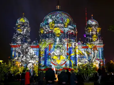 Sejumlah wisatawan mengamati Katedral Berlin yang dihiasi cahaya saat Festival Cahaya di Berlin, Jerman, Sabtu (10/10/2015). Festival ini merupakan event tahunan yang diadakan setiap bulan Oktober selama dua belas hari.(REUTERS/Hannibal Hanschke)