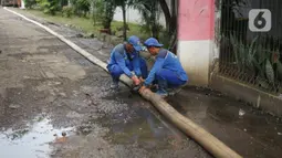 Petugas Sudin Sumber Daya Air Jakarta Timur membersihkan saluran gorong-gorong yang tertutup lumpur dan sampah di kawasan Pasar Rebo, Kamis (19/3/2020). Pembersihan untuk memperlancar sistem drainase yang tersumbat dan kerap menimbulkan genangan air di kawasan itu. (Liputan6.com/Immanuel Antonius)