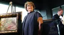 Cucu pewaris terakhir, Sylvie Sulitzer berpose dengan lukiskan karya Renoir yang dikembalikan dalam upacara di New York, Rabu (12/9). Lukiskan itu dikembalikan setelah 70 tahun berkelana dari Afrika Selatan, London, Swiss dan New York. (SPENCER PLATT/AFP)