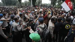 Demonstran driver online saling dorong dengan pihak kepolisian saat unjuk rasa di depan Istana Negara, Jakarta, Rabu (14/2). Kericuhan nyaris terjadi lantaran demonstran mencegat para driver online yang masih beroperasi. (Liputan6.com/Arya Manggala)