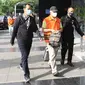 Bupati Banggai Laut, Sulawesi Tengah (Sulteng), Wenny Bukamo dikawal petugas saat tiba di Gedung Merah Putih KPK, Jakarta, Sabtu (5/12/2020). Wenny Bukamo terjerat Operasi Tangkap Tangan (OTT) KPK dalam dugaan kasus suap untuk kepentingan kampanye pemenangan. (Liputan6.com/Herman Zakharia)